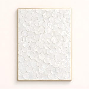 Puede incluir: Una obra de arte enmarcada con una superficie texturizada compuesta por numerosos elementos circulares blancos. La obra está encerrada en un marco delgado de color dorado, creando una estética minimalista y elegante. Los círculos blancos crean un patrón.