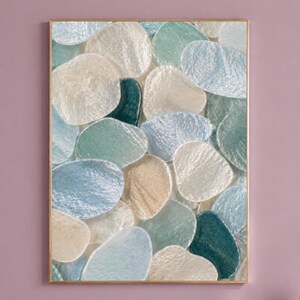 Puede incluir: Una impresión de arte mural rectangular que presenta un patrón denso y superpuesto de formas redondeadas, translúcidas e iridiscentes en tonos verde espuma de mar, azul pálido, crema y verde azulado oscuro, enmarcada en un fino marco dorado.