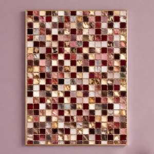 Puede incluir: Una pieza de arte mural rectangular que presenta una cuadrícula de pequeños azulejos cuadrados en tonos burdeos intenso, rosa suave, crema y oro metálico. Los azulejos tienen una textura marmolada y están enmarcados por un marco de metal dorado.