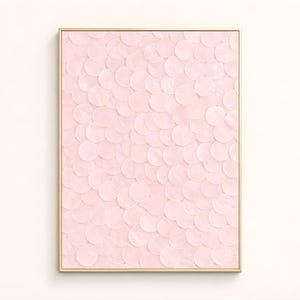 May include: A framed artwork featuring a textured surface of overlapping, light pink circles. The circles create a pattern across the canvas, and the artwork is encased in a thin, gold-colored frame. The piece is a decorative wall art.