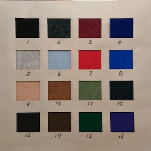 May include: A color chart featuring sixteen squares of felt in various colors, each labeled with a number from 1 to 16. The colors include black, blue, red, green, and neutral tones like beige and gray. The chart is on a light brown background.
