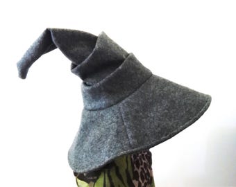 May include: A gray felt wizard hat with a tall, pointed crown and a wide brim. The hat is made of a soft, comfortable material and has a classic wizard design.