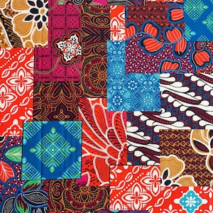 Op de afbeelding: Een patchwork textiel met een mix van vierkanten met patronen. Het ontwerp bevat bloemen, geometrische en abstracte motieven in een rijk palet van rood, blauw, oranje en bordeaux. De stof lijkt katoen of een vergelijkbaar materiaal te zijn.
