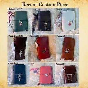 May include: A collection of custom leather journals in various colors, including green, black, white, dark chocolate, burgundy, caramel, royal blue, pink, and tobacco. Each journal features a unique charm and decorative accents. The text "Recent Custom Piece" is at the top.