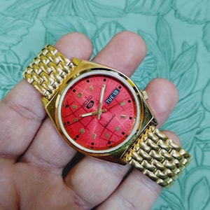 Montre automatique Seiko 5 vintage, cadran classique rouge cerise, boîtier doré, acier inoxydable unisexe de 37,5 mm.