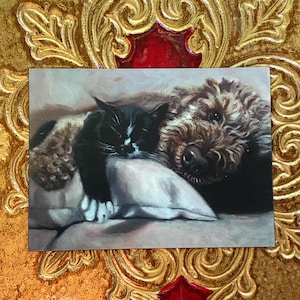 May include: A rectangular print featuring a black and white cat resting on a pillow next to a brown dog. The cat is curled up, and the dog is nestled close. The print has a soft, painterly style.
