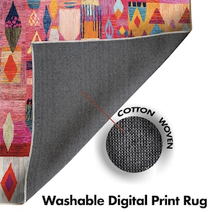 May include: A vibrant, geometric patterned rug with a pink backdrop and shapes in orange, blue, and yellow. The rug is labelled "Washable Digital Print Rug" and is made of cotton.