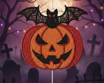 May include: A Halloween-themed hanging decoration featuring a jack-o'-lantern with a bat on top and a spider below. The pumpkin is orange and red with a carved face. The bat is black with red eyes. The spider is white. The background shows a graveyard.