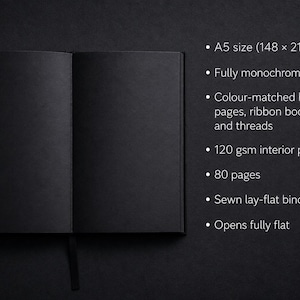 Black hardcover journal with thick black paper for high contrast creative work. Ideal for sketching, notes, and visual journaling with markers. The understated design is elevated by a subtle pink accent page near the back.