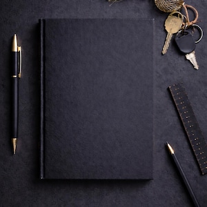 Minimalist black paper journal made for creative writing, sketching, and artistic notes using markers. The hardcover keeps the design clean and professional. Thick black pages prevent bleed-through, while a bright pink accent at the end adds a modern luxury touch.