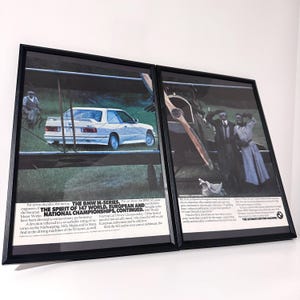 Könnte beinhalten: Zwei gerahmte Vintage-BMW-Werbeanzeigen. Eine zeigt ein weißes BMW-Auto, die andere ein Doppeldecker und Personen. Der Text enthält "THE BMW M-SERIES" und "THE ULTIMATE DRIVING MACHINE".