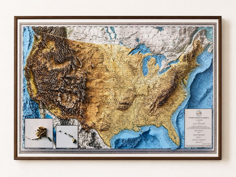 May include: A framed 3D relief map of the United States, showcasing topographical features in shades of brown, tan, and blue. The map includes inset images of Alaska and Hawaii. The frame is dark brown with a silver border.