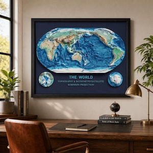 May include: A framed 3D topographical map of the world, showcasing land elevation and ocean depths in shades of green, brown, and blue. The map is labeled "THE WORLD" with "TOPOGRAPHY & BATHYMETRY (SATELLITE) ROBINSON PROJECTION" below. The frame is black.