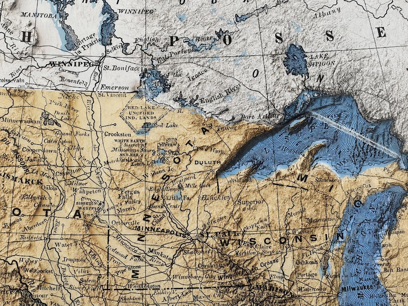 May include: A detailed vintage map of the upper Midwest region of the United States and parts of Canada. The map features a sepia-toned background with blue water features, including the Great Lakes and Lake Winnipeg. Cities and geographical features are labeled.