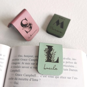 Peut inclure: Trois marque-pages magnétiques en rose, vert olive et vert clair. Le rose porte une lettre S florale et le prénom Sabrina. Le vert olive affiche une lettre M et le prénom Marco. Le vert clair présente une lettre L florale et le prénom Lucile.
