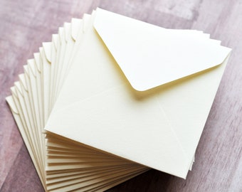 May include: A stack of ivory envelopes, neatly arranged, with a single envelope on top. The envelopes are blank and ready for use.