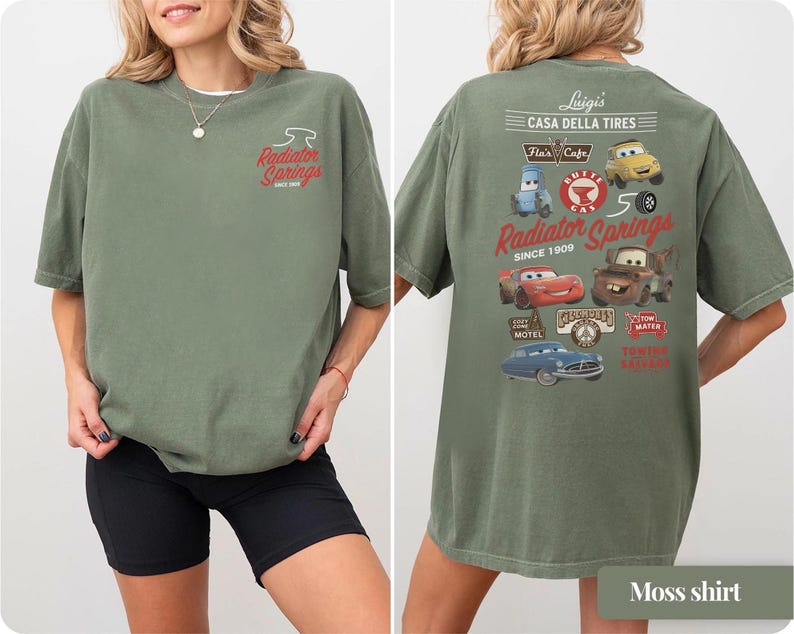 May include: An olive green t-shirt featuring a small Radiator Springs logo on the front chest. The back displays a large graphic with various Cars characters, including Lightning McQueen and Mater, alongside text reading Luigi's Casa Della Tires.