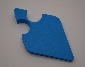May include: A textured, bright blue foam tool with a unique shape, featuring a curved handle and a rounded edge. The tool has a cutout and a textured surface. The item is on a neutral background.