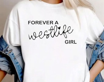 May include: A white short-sleeved t-shirt featuring the black printed text FOREVER A westlife GIRL with a small heart icon above the word westlife. The shirt is worn under a blue denim jacket with visible metal buttons and distressed fabric details.