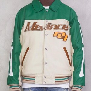 May include: A green and cream-colored varsity jacket with the text "M. Vince" in brown lettering. The jacket has a button-up front, brown pocket trim, and striped cuffs and hem. The sleeves have white bone-like accents.