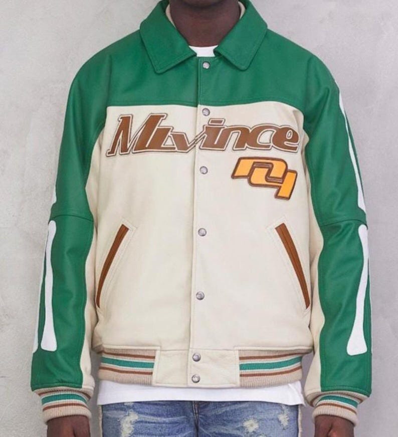 May include: A green and cream-colored varsity jacket with the text "M. Vince" in brown lettering. The jacket has a button-up front, brown pocket trim, and striped cuffs and hem. The sleeves have white bone-like accents.
