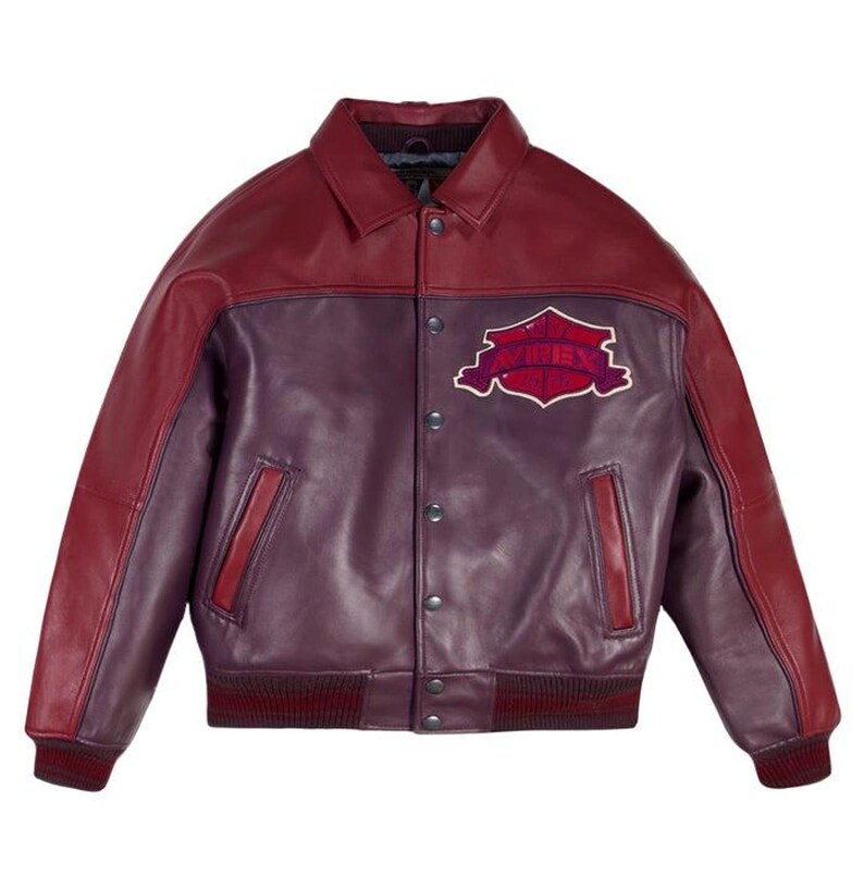 Pode incluir: Casaco de couro bord&ocirc; e roxo com gola e fecho de bot&otilde;es. O casaco apresenta um patch no peito com o texto "AVIREX". Punhos e bainha canelados. Um estilo cl&aacute;ssico de jaqueta bomber.