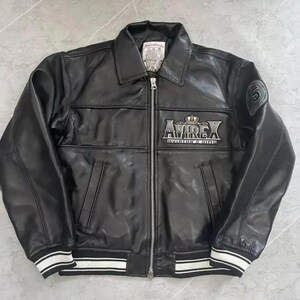 May include: Black leather jacket with a zip-up front, collar, and white striped cuffs and hem. The jacket features the "AVIREX" logo on the chest and a patch with the number "5" on the sleeve. A classic outerwear piece.