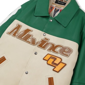 May include: A green and cream-colored varsity jacket with the word "Mlvince" in brown lettering. The jacket has a green collar and trim, with a cream-colored body and brown accents. The number "27" is displayed in orange.