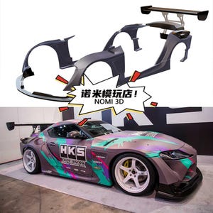 Peut inclure: Une voiture de sport grise avec un kit carrosserie personnalisé et un grand aileron arrière. La voiture a un habillage graphique coloré avec le logo HKS. Au-dessus, les composants démontés du kit carrosserie sont affichés. Le texte "NOMI 3D" est visible.