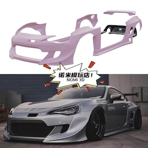May include: A light pink car body kit, disassembled, above a silver sports car with a black front grill and black wheels. The image includes the text "NOMI 3D" in a yellow and red graphic.