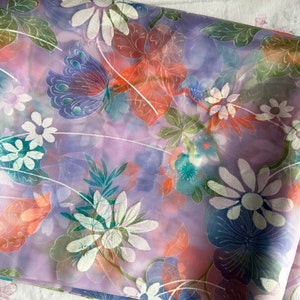 May include: Purple sheer fabric with a floral print featuring butterflies, flowers, and leaves in shades of pink, blue, green, and white.