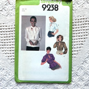 Puede incluir: Patrón de costura Simplicity número 9238 para una blusa. El patrón muestra cuatro estilos diferentes de blusas con una variedad de escotes y longitudes de manga. El patrón es para la talla 10 miss.