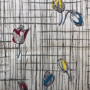 May include: A white fabric with a gray grid pattern and colorful tulip illustrations. The tulips are red, yellow, and blue.