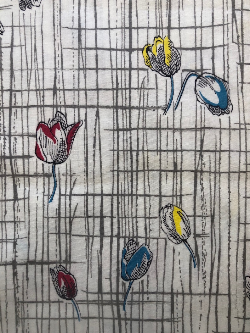 May include: A white fabric with a gray grid pattern and colorful tulip illustrations. The tulips are red, yellow, and blue.