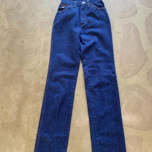 May include: A pair of dark blue denim jeans with a high waist and straight legs.