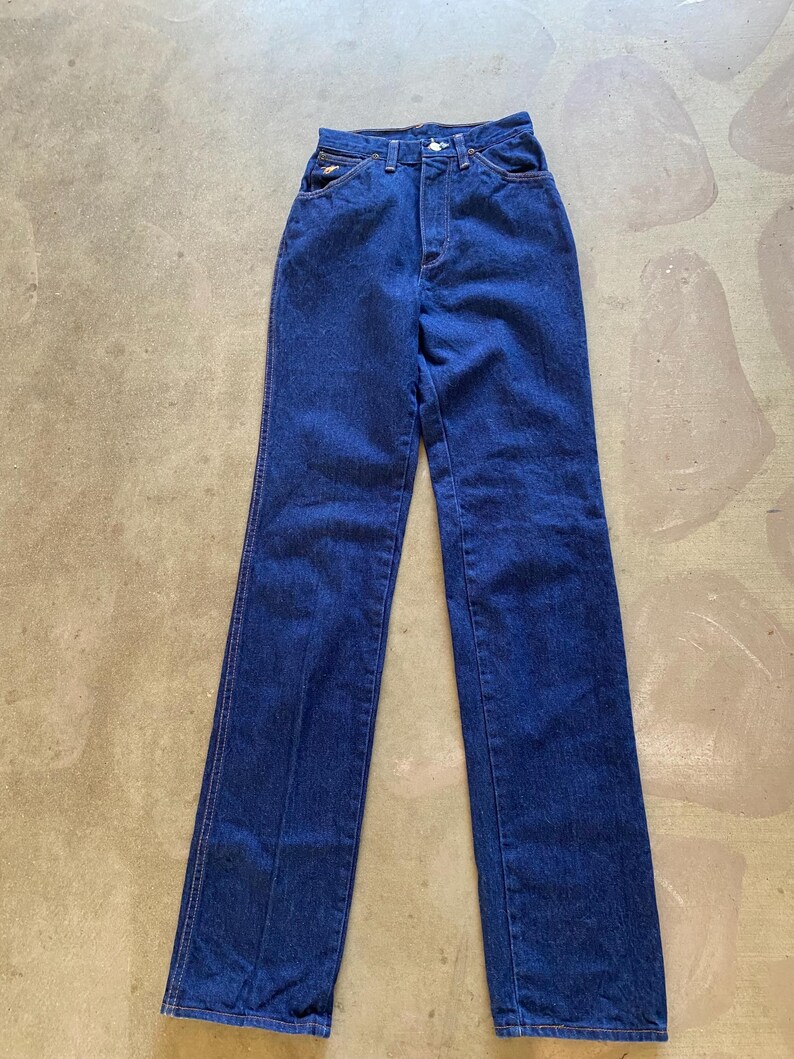 May include: A pair of dark blue denim jeans with a high waist and straight legs.