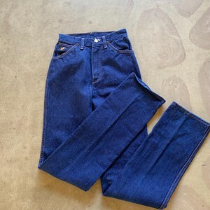 May include: A pair of dark blue denim jeans with a high waist and a straight leg.