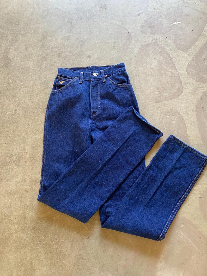 May include: A pair of dark blue denim jeans with a high waist and a straight leg.
