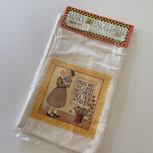 May include: A white canvas tote bag with a colorful illustration of a girl holding a globe. The illustration includes the text "Hurt not the earth neither sea nor the trees" and "Revelations 7:3".