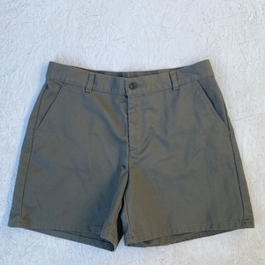 May include: A pair of olive green cargo shorts with two front pockets and a button closure.