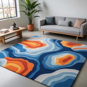 Può includere: Un tappeto rettangolare con un motivo a mappa topografica caratterizzato da forme organiche stratificate in tonalità blu scuro, blu chiaro, arancione e giallo. Il design è composto da contorni concentrici fluidi che creano profondità.