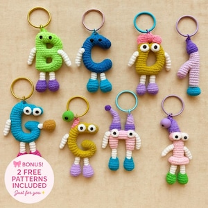 Könnte beinhalten: Eine Sammlung farbenfroher, gehäkelter Buchstaben-Schlüsselanhänger. Jeder Schlüsselanhänger zeigt einen anderen Buchstaben des Alphabets, mit Wackelaugen, Armen, Beinen und einem Schlüsselring. Die Buchstaben sind in verschiedenen Farben gehalten, darunter Grün, Blau, Gelb und Rosa. Der Text "BONUS! 2 FREE PATTERNS INCLUDED Just for you +" ist ebenfalls enthalten.