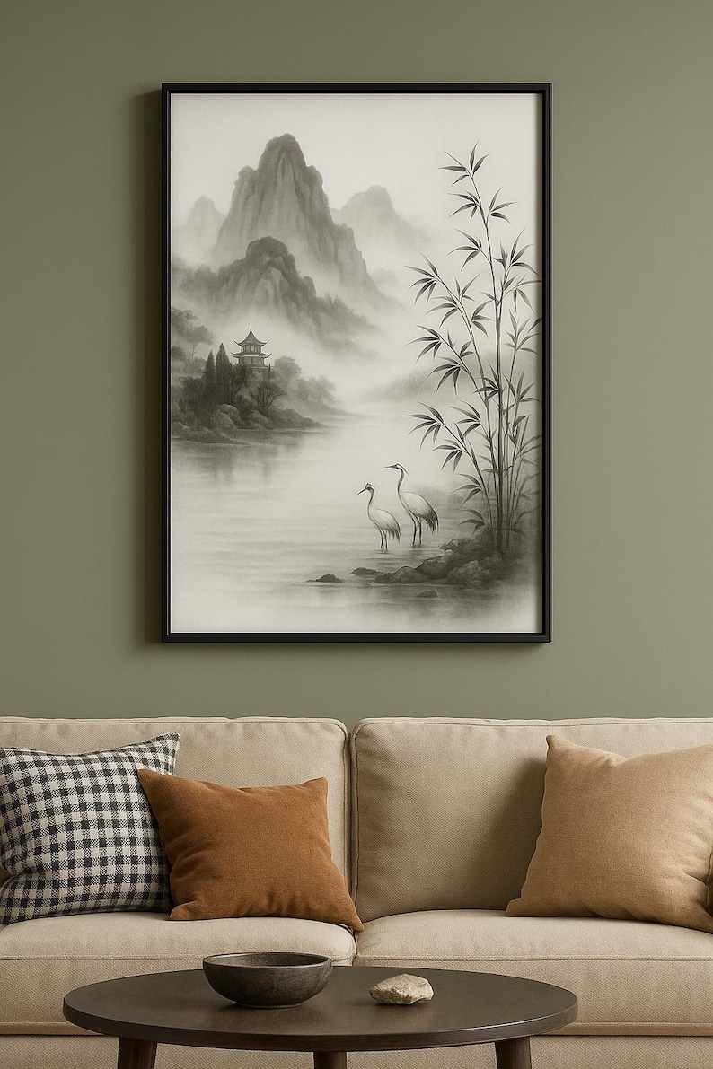 Op de afbeelding: Zwartgelijste kunstdruk met een serene Aziatische landschap. Het kunstwerk toont een mistige bergketen, een pagode en twee witte vogels bij bamboestengels. Het kleurenpalet is voornamelijk grijs met zachte, gedempte tinten.