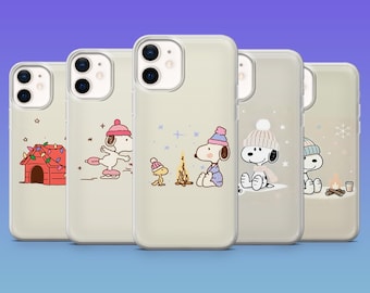 May include: Five phone cases with Snoopy winter designs. Each case shows a different illustration, including Snoopy ice skating, by a campfire, and in front of his doghouse with Christmas lights. The cases have a clear, neutral background.