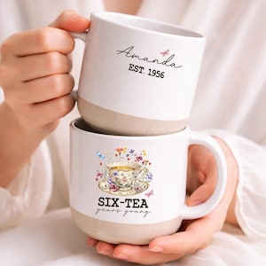 May include: A set of three ceramic mugs with a speckled, matte finish in cream, light brown, and dark brown. Each mug features a minimalist design and a rounded handle.