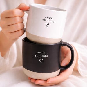 May include: A trio of ceramic mugs with a speckled, matte finish in cream, light grey, and dark grey. Each mug features a simple, minimalist design, ideal for tea or coffee.