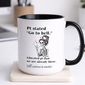 May include: White ceramic mug with a black interior and handle. The mug features a skeleton nurse graphic and the text "Pt stated 'Go to hell.' Educated pt that we are already there. Will continue to monitor."