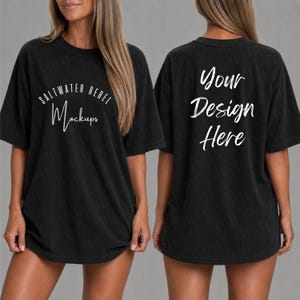 Könnte beinhalten: Schwarzes übergroßes T-Shirt-Mockup. Auf der Vorderseite des Shirts steht in weißer Schrift der Text "SALTWATER REBEL Mockups". Auf der Rückseite des Shirts steht in weißer Schrift der Text "Your Design Here". Das Shirt hat kurze Ärmel und einen Rundhalsausschnitt.