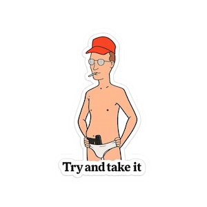 Op de afbeelding: Een sticker met een stripfiguur die een rode pet, een ronde bril en een witte onderbroek draagt, met een sigaret in de mond en een zwart voorwerp in de tailleband gestoken. De tekst eronder luidt Try and take it in zwarte letters.
