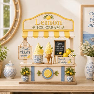 Könnte beinhalten: Ein hölzerner Zitroneneisstand mit gelb-weiß gestreifter Markise, einer Menütafel und Schildern mit der Aufschrift "Lemon ICE CREAM", "Cool TREATS sweet" und "Fresh & Zesty". Der Stand ist mit Zitronenmotiven und blauen Mustern verziert.